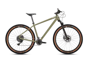 Olivgrünes MAXX Pacemaxx Sport Mountainbike mit braunen Reifen, Schwalbe Nobby Nic Bereifung und Shimano CUES Antrieb.