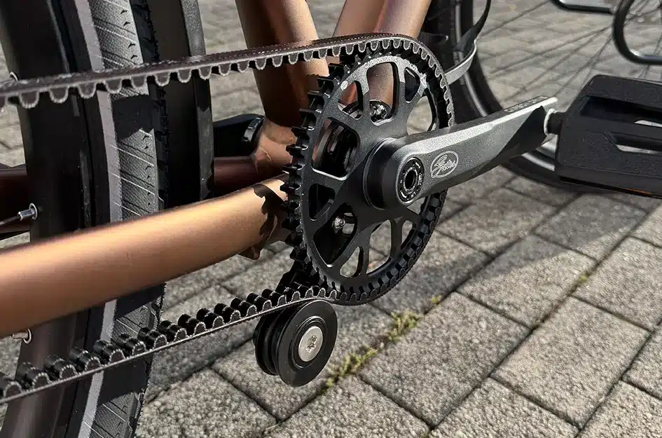 Detailansicht des Gates Carbon Drive Riemenantriebs mit Kurbel und Zahnkranz an einem MAXX Pacemaxx Sport Fahrrad.