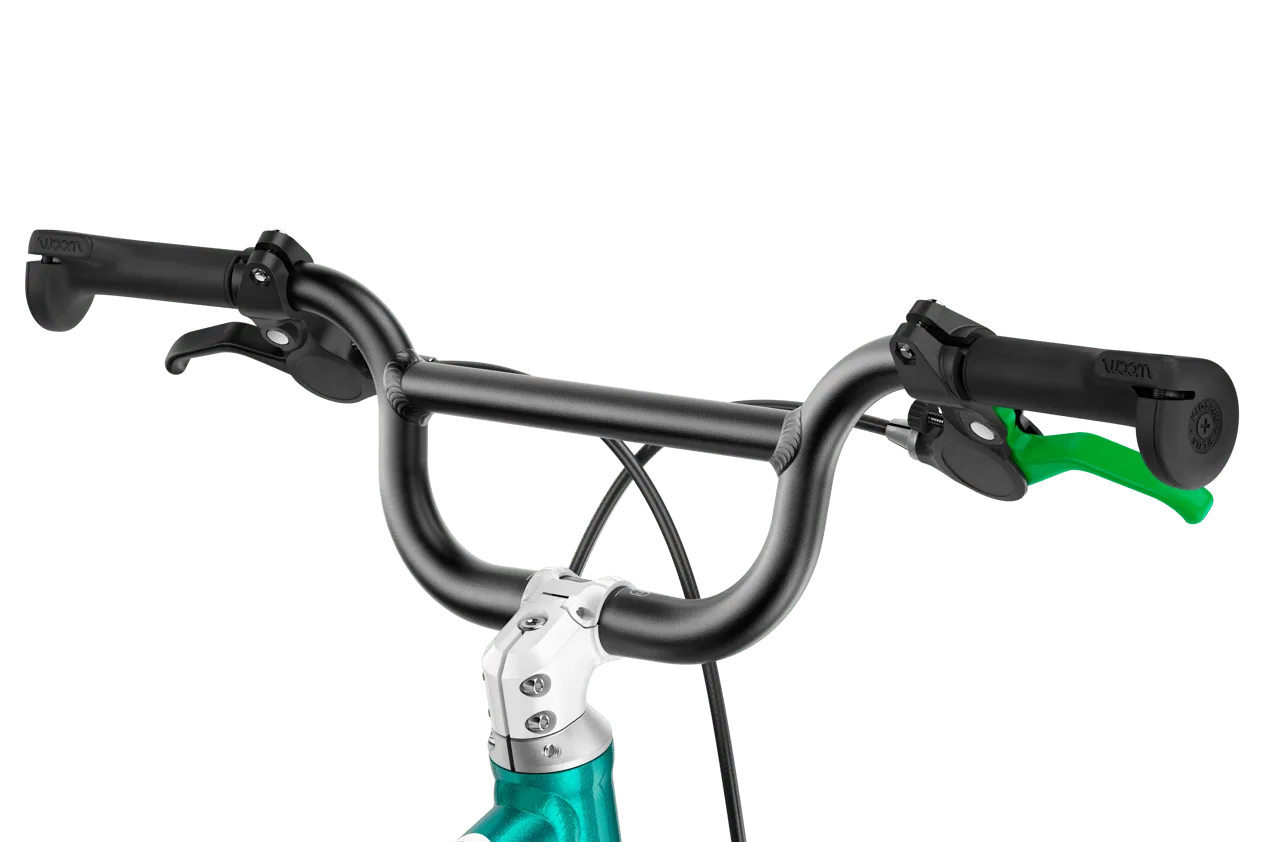 Nahaufnahme des Lenkers eines woom GO 3 AUTOMAGIC Kinderfahrrads mit schwarzen Griffen, schwarzem Lenker und einem grünen Bremshebel.