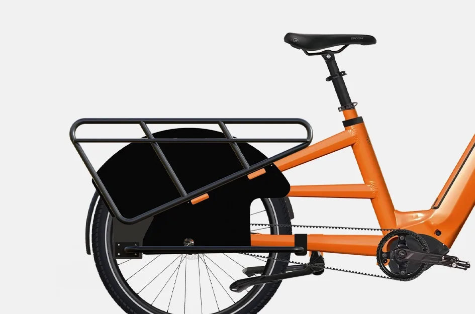 Seitenansicht eines orangen Maxx Maxximo Urban Longtail-E-Bikes mit schwarzem Gepäckträger und schwarzem Schutzblech.