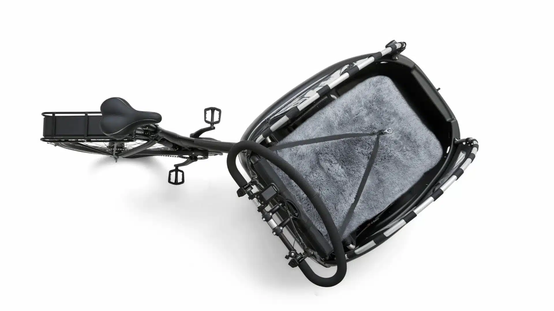 Vogelperspektive auf ein schwarzes dreirädriges Lastenrad, Modell Kangaroo Luxe Dog, mit Fokus auf die geräumige Ladekabine, ausgekleidet mit flauschigem grauen Teppich und gesichert durch Gurte.