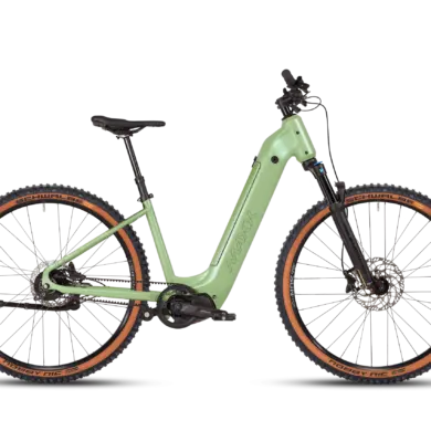 Vollansicht des MAXX Pacemaxx Comfort ELS Sport E-Bikes in Hellgrün mit Fokus auf den robusten Rahmen, die Federgabel und die breiten Reifen mit braunen Seitenwänden.