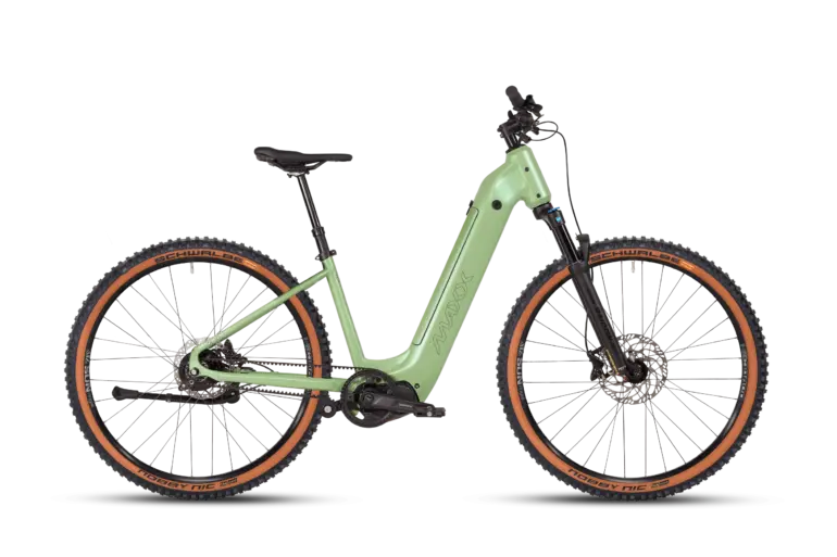 Vollansicht des MAXX Pacemaxx Comfort ELS Sport E-Bikes in Hellgrün mit Fokus auf den robusten Rahmen, die Federgabel und die breiten Reifen mit braunen Seitenwänden.