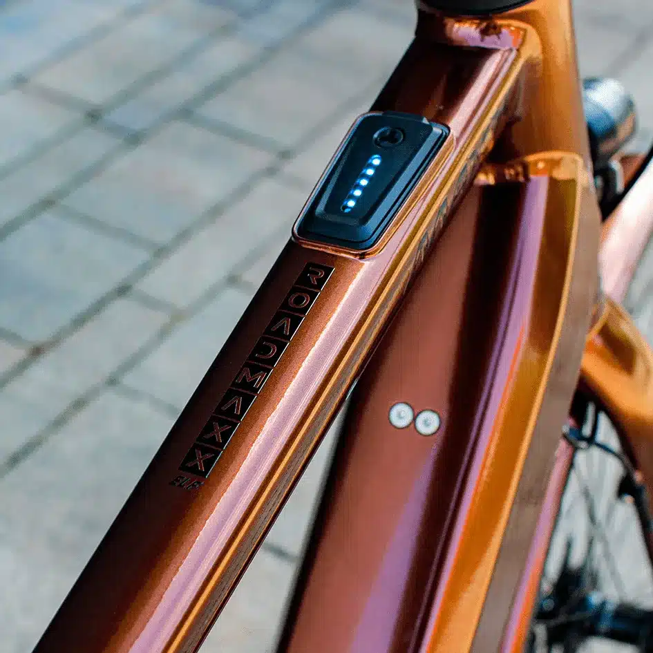 Detailansicht des Rahmens eines braunen MAXX Roadmaxx ELF Tour E-Bikes mit einer Anzeige für den Akkustand.