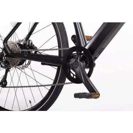 Nahaufnahme der Antriebskomponenten eines schwarzen GEERO 2 E-Bikes, inklusive Kurbel, Pedale, Kette und Kassette am Hinterrad.