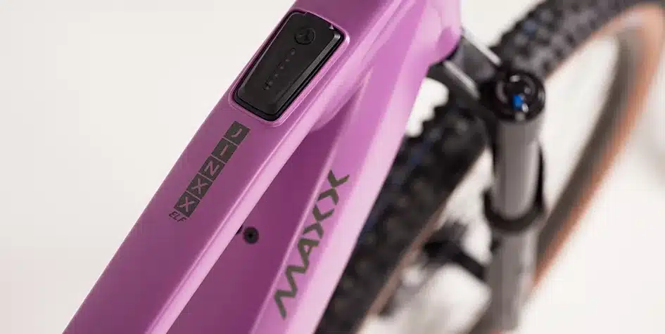Nahaufnahme eines violetten Rahmens eines E-Mountainbikes. Deutlich sichtbar sind der Schriftzug