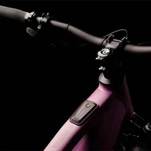 Detailaufnahme des lila Rahmens eines MAXX Jinxx ELF Ride 60 E-Mountainbikes mit dem integrierten Fazua Ride 60 Akku- und Motormodul sowie dem schwarzen Lenker.