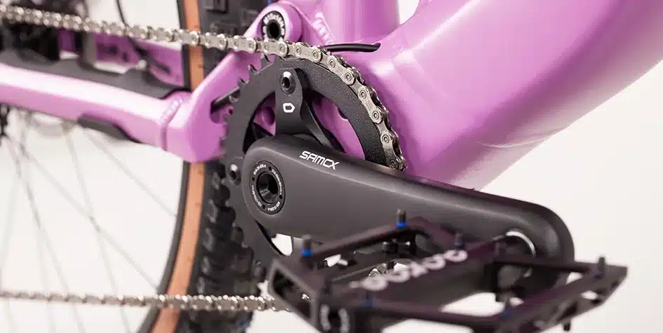 Detailbild der Kurbelgarnitur, des Kettenblatts und der Kette eines lila MAXX Jinxx ELF Ride 60 E-Mountainbikes.