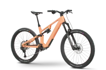 Rose File Plus XT E-MTB in der Farbe Koralle, von der Seite fotografiert mit einem schwarzen Hintergrund.