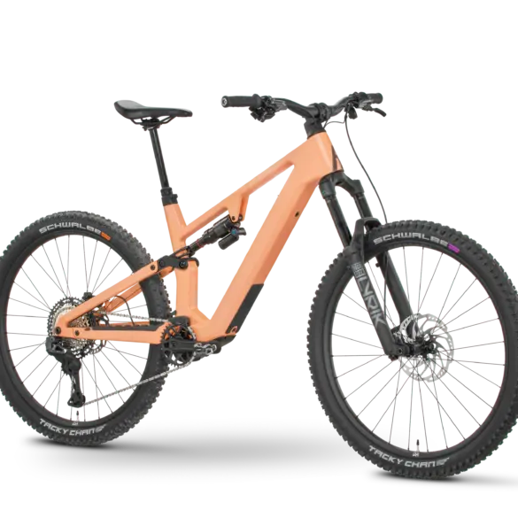 Rose File Plus XT E-MTB in der Farbe Koralle, von der Seite fotografiert mit einem schwarzen Hintergrund.