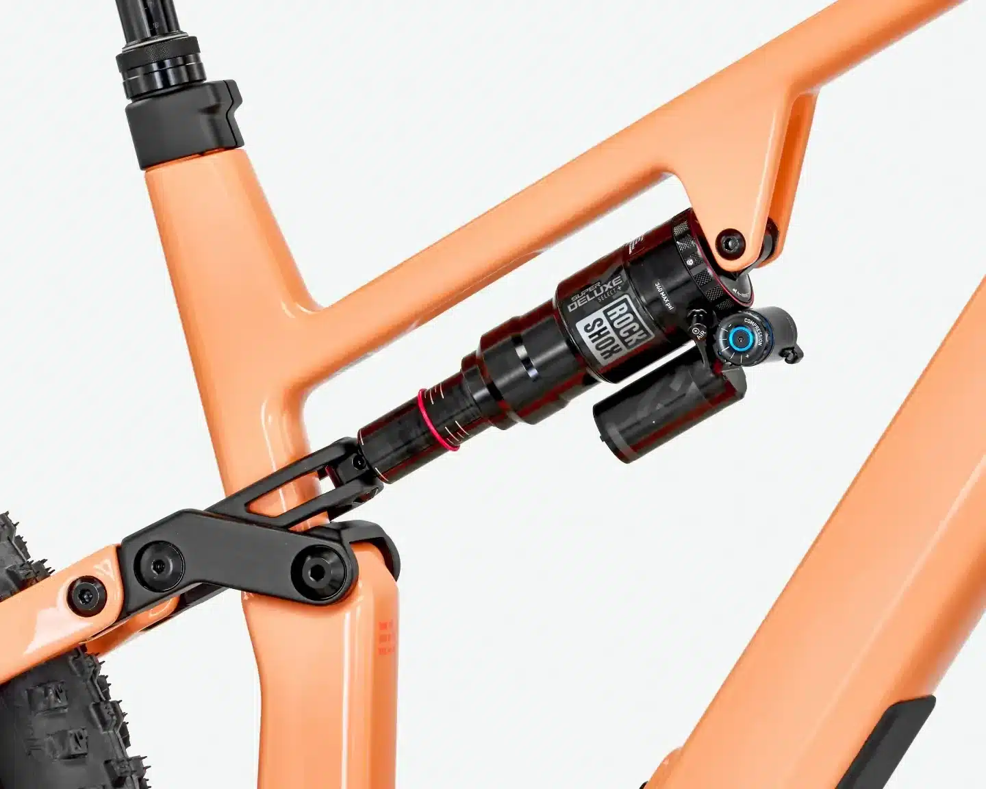 Nahaufnahme des orangefarbenen Rahmens eines Rose File Plus XT E-MTBs, Fokus auf den RockShox Super Deluxe Select+ Dämpfer und die Hinterradaufhängung.