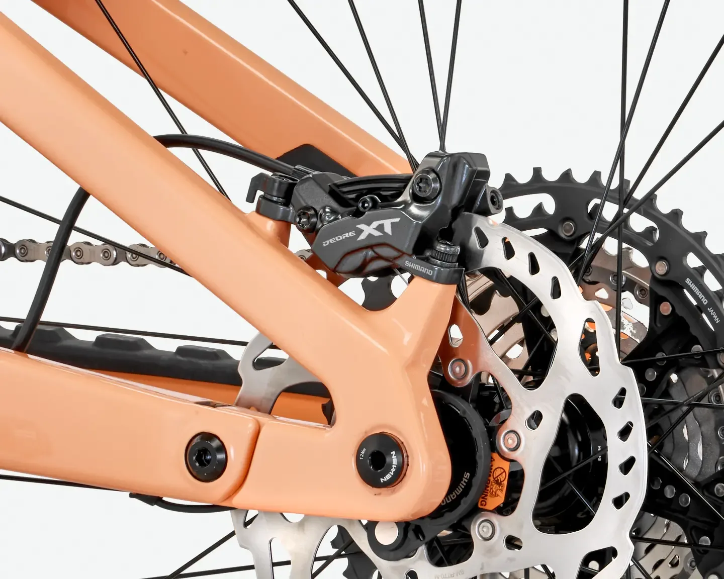 Nahaufnahme der hinteren Scheibenbremse und des Ritzelpakets eines orangefarbenen Rose File Plus XT E-Mountainbikes.