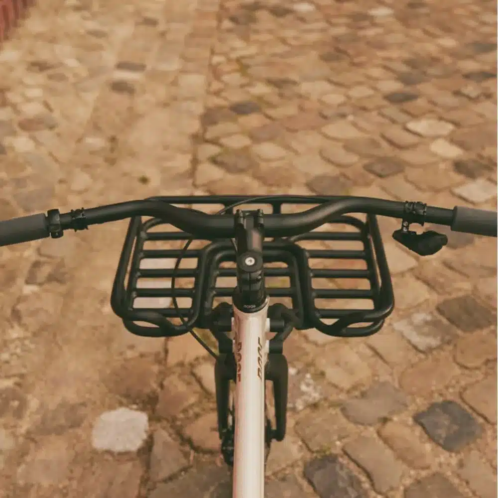 Vorderansicht eines Hobo-Fahrrads mit einem integrierten schwarzen Frontträger, montiert auf Kopfsteinpflaster.