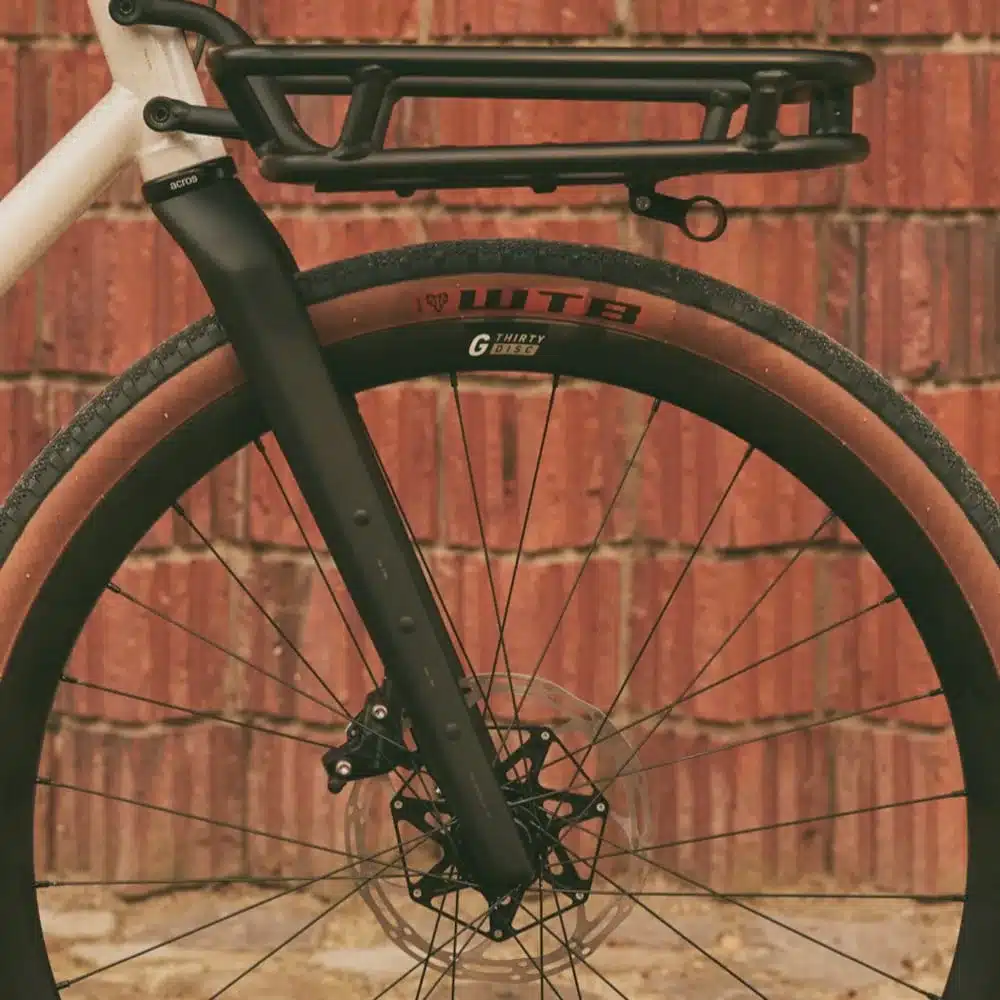 ROSE Hobo Fahrrad: Detailansicht der Vordergabel mit integriertem Gepäckträger, WTB Gravel Reifen und Scheibenbremse.