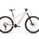 Seitenansicht eines ROSE Bonero Plus 1 E-Mountainbikes in heller Farbgebung mit Vollcarbon-Rahmen, TQ-HPR50 Motor und RockShox Federgabel.