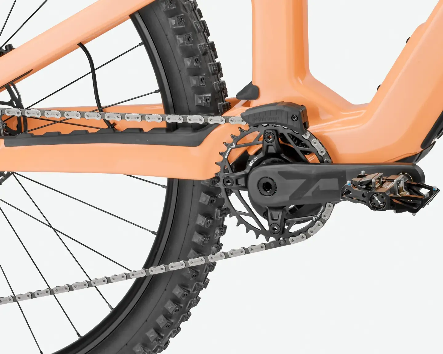 Nahaufnahme der Kettenlinie, des Motors und des Pedals eines orangefarbenen Rose File Plus 70 Mountainbikes.