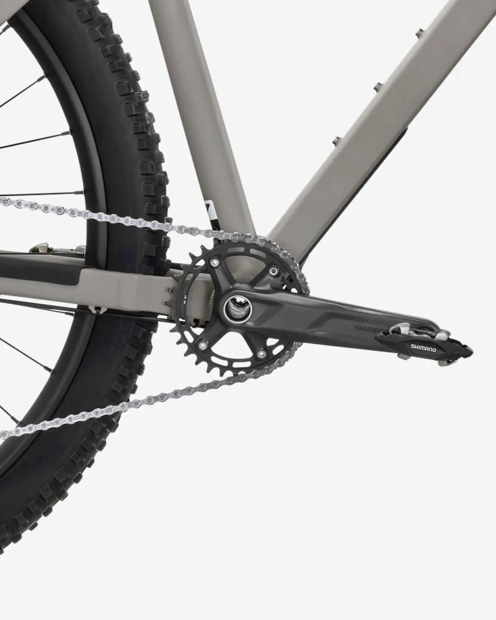 Nahaufnahme des Antriebsstrangs eines Rose PDQ AL 1 Fahrrads mit Shimano Kurbel und Kette sowie breitem Reifen.