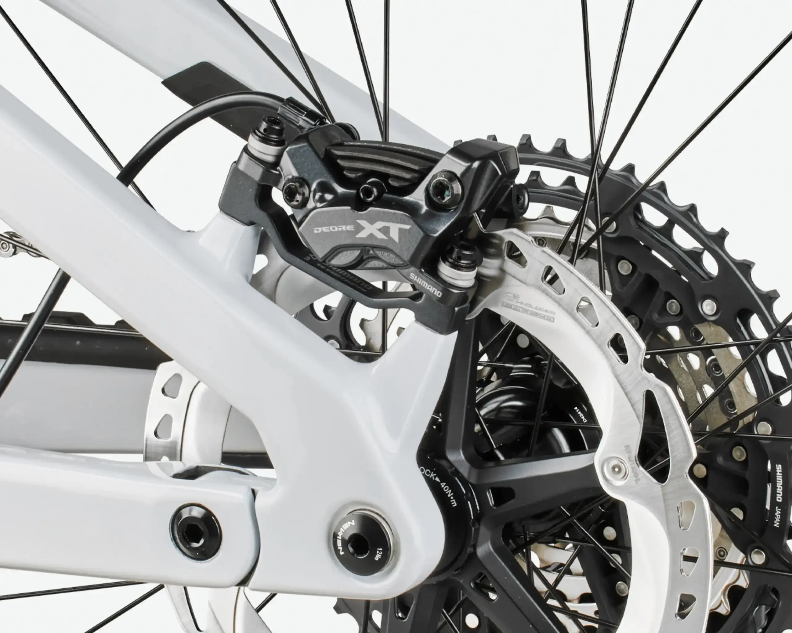 Nahaufnahme der Shimano Deore XT Scheibenbremse und der Kassette mit 12 Gängen an der Hinterradnabe eines Mountainbikes.