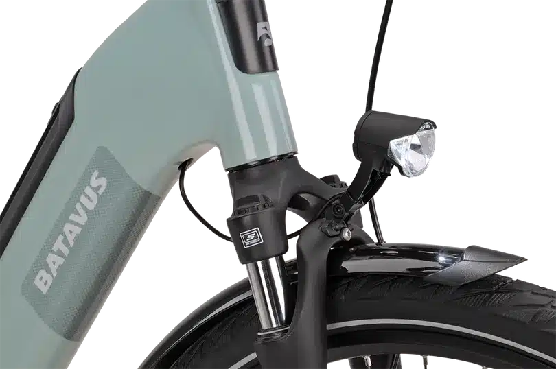 Nahaufnahme des Vorderrads eines mintgrünen Batavus E-Bikes mit heller Frontleuchte und Federgabel.