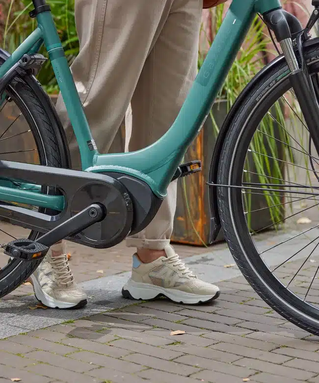 Detailaufnahme des Rahmens eines Gazelle Paris E-Bikes in Petrol, der Mittelmotor und die Pedale sind sichtbar.