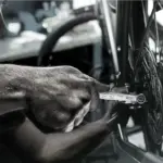 Mechaniker repariert Fahrradschaltwerk mit Joker 6003 Schraubenschlüssel.