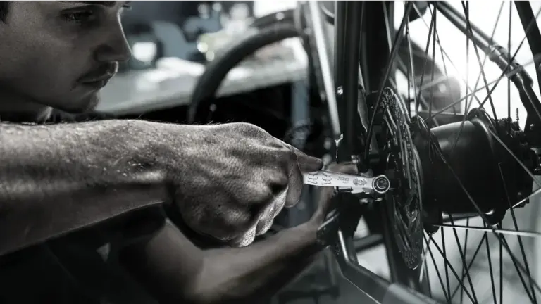 Mechaniker repariert Fahrradschaltwerk mit Joker 6003 Schraubenschlüssel.