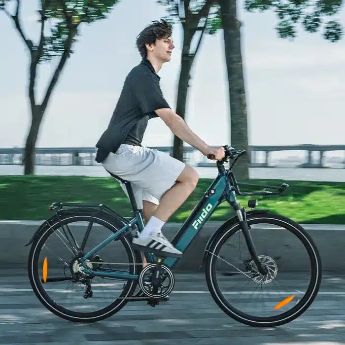 Ein junger Mann fährt mit einem dunkelblauen Fiido C11 Pro E-Bike auf einer Straße.