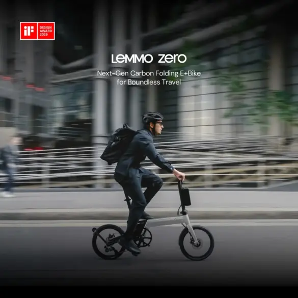 Mann mit Helm fährt ein Lemmo Zero faltbares E-Bike mit Rucksack auf dem Rücken auf einer Straße, im Hintergrund unscharfe Gebäude und eine Brücke.