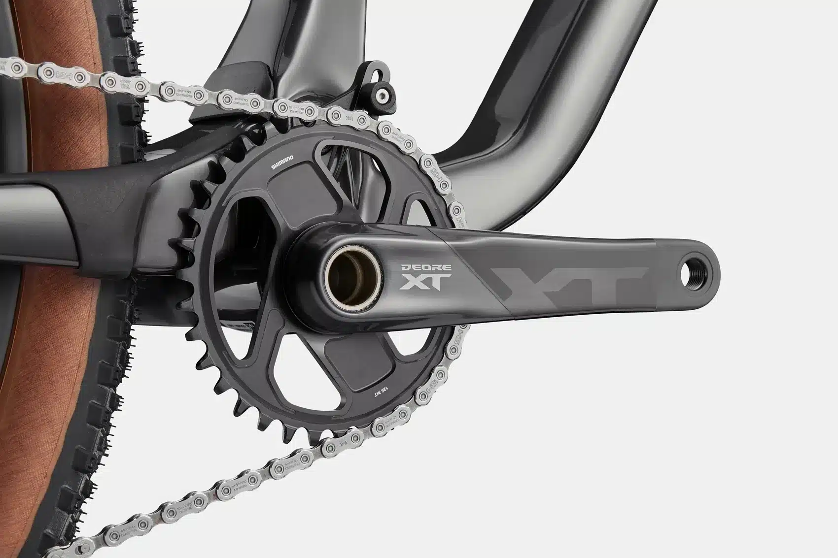 Detailaufnahme der Shimano Deore XT Kurbelgarnitur mit Kette und Teil des Rahmens eines Cannondale Mountainbikes.
