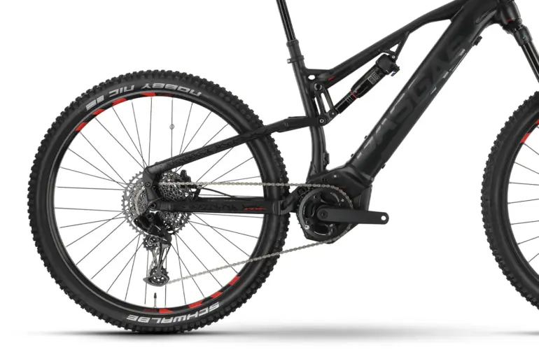 Seitenansicht eines schwarzen GasGas TRA SE E-Mountainbikes mit Fokus auf das Hinterrad, die Federung und den integrierten Akku.
