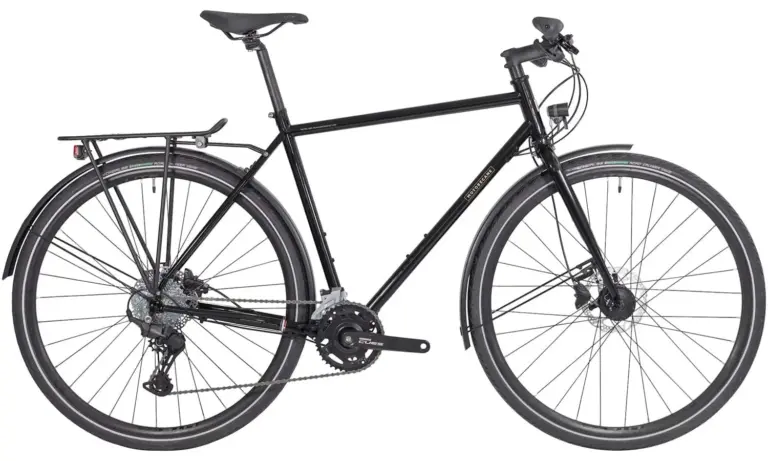 Schwarz lackiertes Motobécane Randonneur Fahrrad mit Gepäckträgern, Schutzblechen und breiten Reifen.