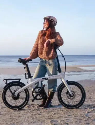 Frau mit ADO Air Carbon Pro Faltrad am Strand mit Meer im Hintergrund