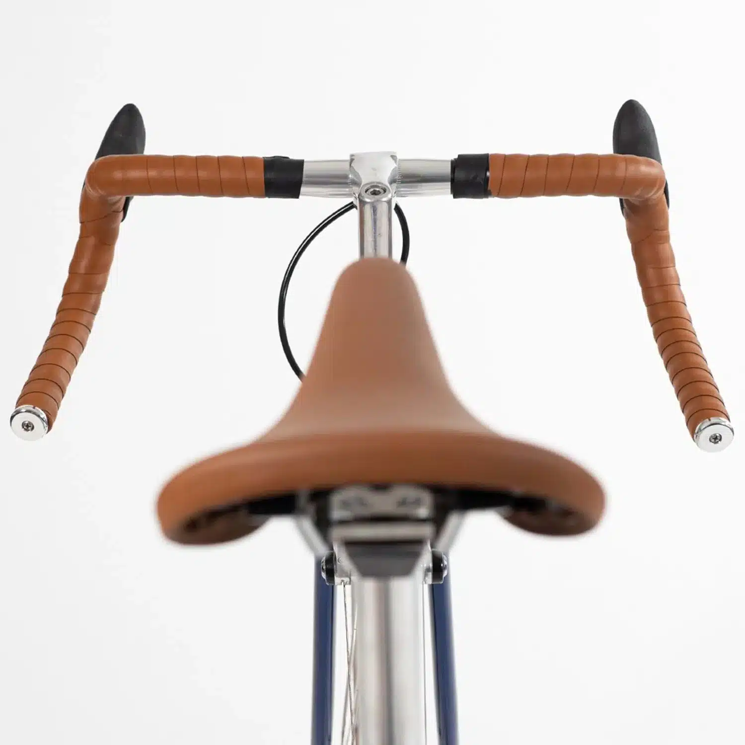 Nahaufnahme des Lenkers und Sattels eines klassischen Rennrad-inspirierten City-Bikes, mit Fokus auf das braune Lenkerband und den braunen Sattel.