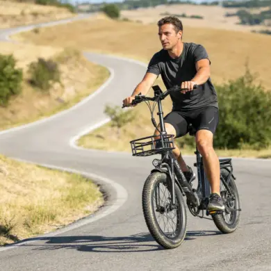 Mann fährt Dukawey T20 Pro E-Bike mit tiefem Einstieg, breiten Reifen und Gepäckträgern auf einer gewundenen Straße.
