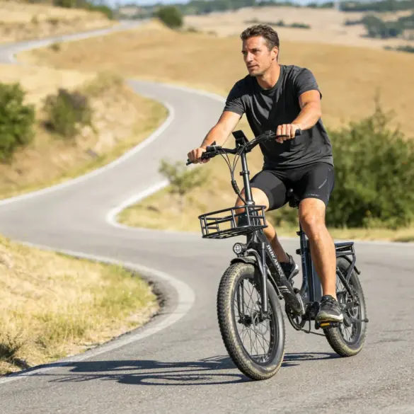 Mann fährt Dukawey T20 Pro E-Bike mit tiefem Einstieg, breiten Reifen und Gepäckträgern auf einer gewundenen Straße.