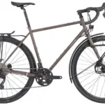 Seitenansicht eines Motobécane 1976-26 Super Randonneur Fahrrads in matt kupferfarben, ausgestattet mit Vorder- und Hinterradträgern sowie Schutzblechen.