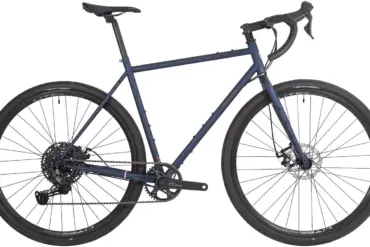 Motobécane TR3 Gravelbike in matt-dunkelblau mit orangefarbenen Dekoren, gesehen von der Seite.