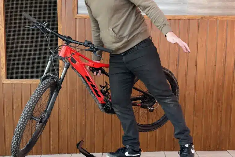 Ein Mann stellt ein rotes E-Bike auf einen schwarzen Ständer namens MXstyle.