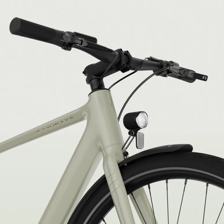 Detailansicht eines hellgrauen TENWAYS CGO600 E-Bikes mit Fokus auf den Lenker, die Vordergabel, den Scheinwerfer und das Vorderrad mit Schutzblech.