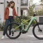 KI-generiertes Bild: Frau mit E-Mountainbike von Cube in einem Wohnviertel
