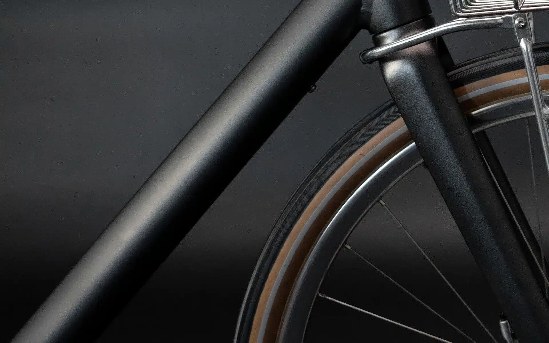 Nahaufnahme des Vorderrads und des Unterrohrs eines mattschwarzen Arthur Cruiser E-Bikes.