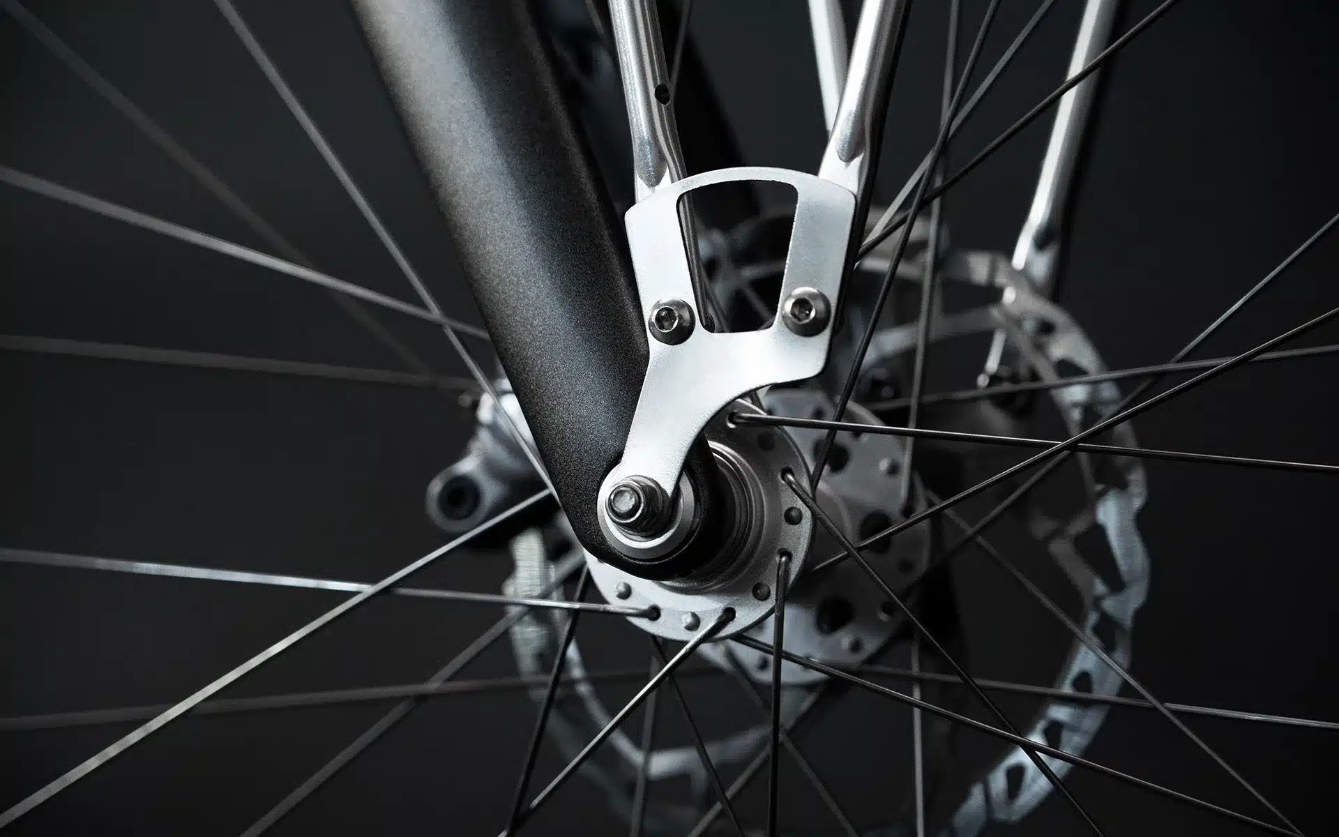 Detailaufnahme des Vorderrads eines Arthur Cruisers E-Bikes, Fokus auf die Gabelmontage, Nabe und Speichen.