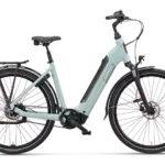 Mintgrünes Batavus Altura PT Pro Exclusive Tiefeinsteiger-E-Bike mit Gepäckträger und Schutzblechen, präsentiert vor schwarzem Hintergrund.