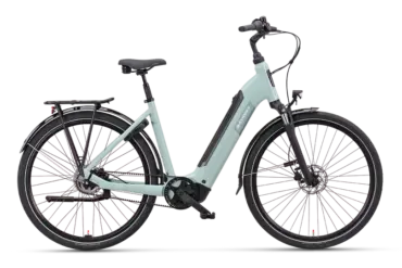 Mintgrünes Batavus Altura PT Pro Exclusive Tiefeinsteiger-E-Bike mit Gepäckträger und Schutzblechen, präsentiert vor schwarzem Hintergrund.