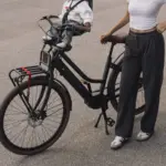 Ein schwarzes LEKKER Jordaan Urban eBike mit einem Kind im Front-Kindersitz. Eine Frau steht daneben.