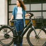 Frau mit dunkelgrauem Lekker Limited Edition GTS E-Bike mit Gepäckträgern und Frontkorb.