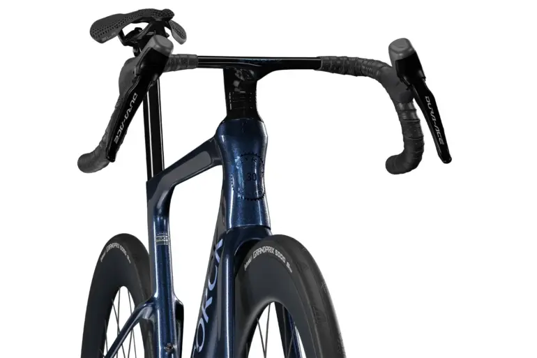 Storck Fascenario.5 30th Rennrad, Detailaufnahme des dunklen, schimmernden Rahmens und des Lenkers mit Shimano Dura-Ace Komponenten.