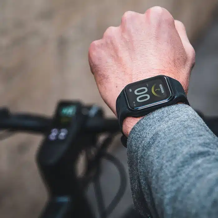 Armbanduhr mit digitalem Display, die Informationen anzeigt, getragen von einer Person im Grauen Pullover.