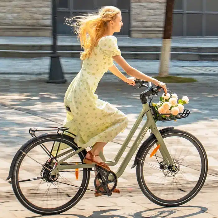 Frau fährt Fiido C700 E-Bike mit Blumen im vorderen Korb