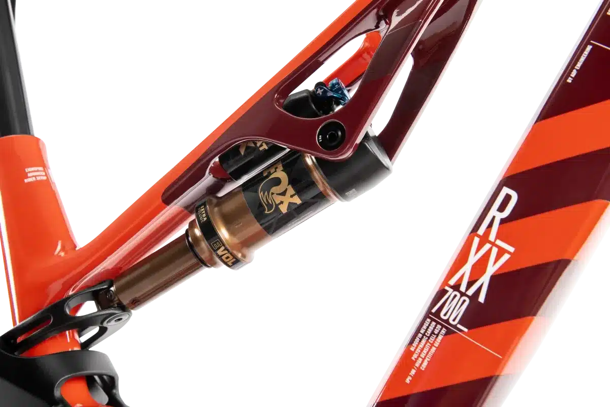 Detailaufnahme des Hinterbaus eines ROTWILD R.XX ULTIMATE E-Mountainbikes mit einem FOX Factory Kashima Dämpfer und einer orange-roten Lackierung.